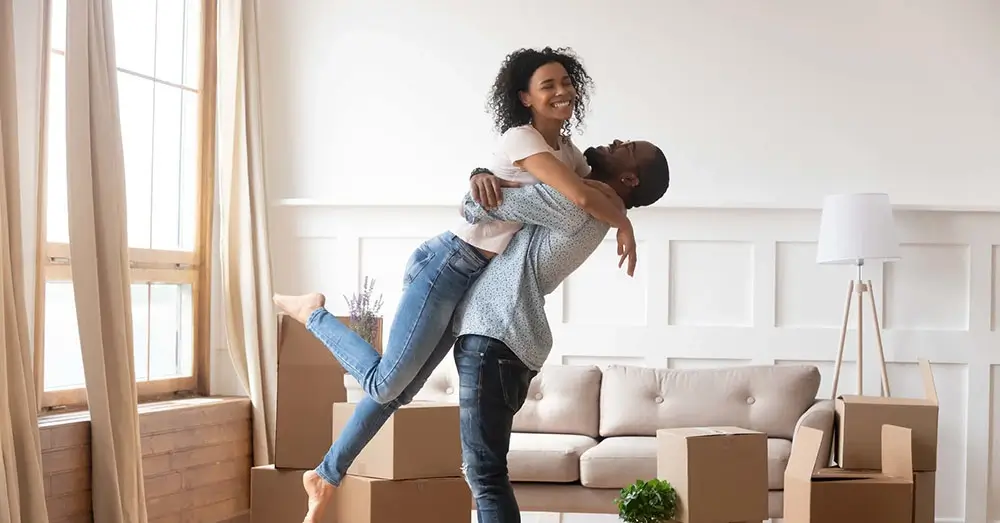 Smiling couple holding keys after selling their Huntsville home